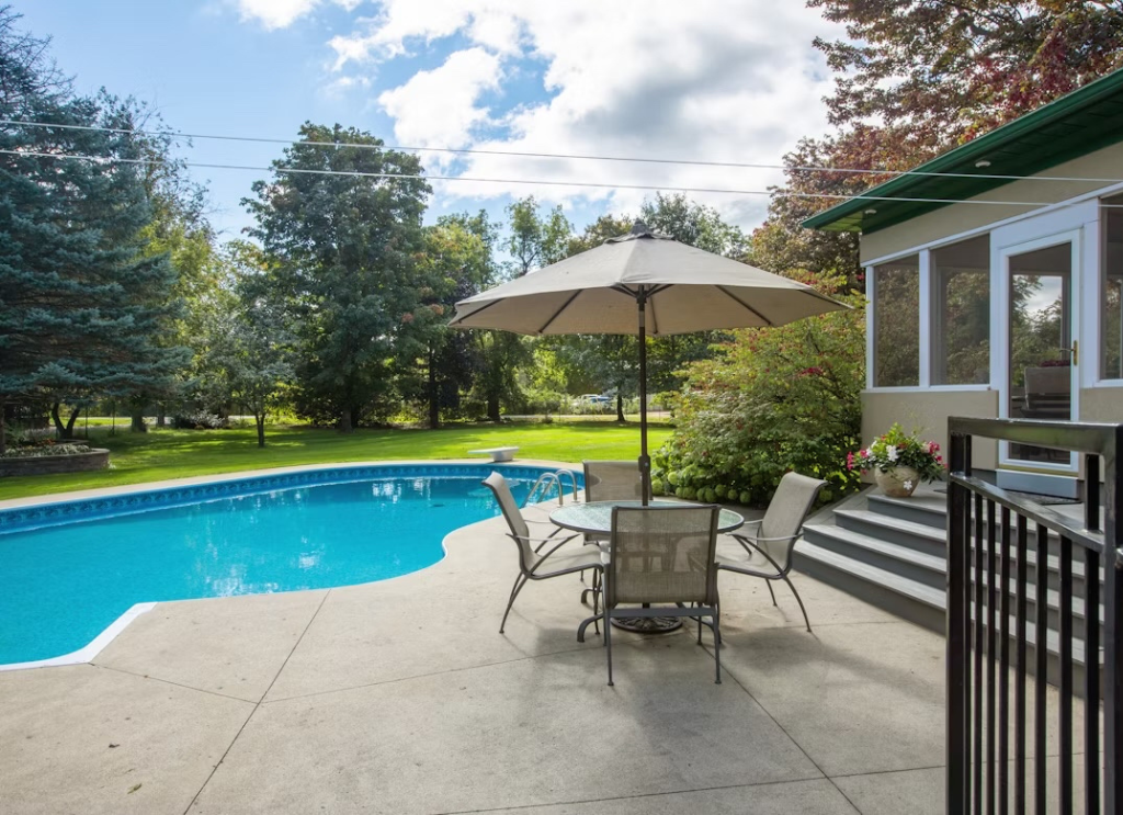 Concrete pool deck surrounding an in-ground pool